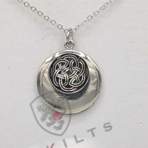 A silver pendant featuring an intricate black and white Celtic design, showcasing a rounded knot pattern.