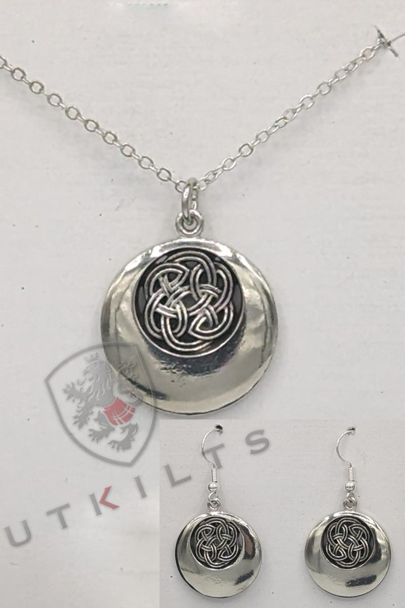 A silver pendant featuring an intricate black and white Celtic design, showcasing a rounded knot pattern.